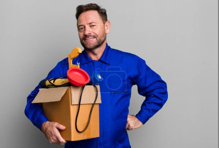 Foto de Middle age plumber man with a toolbox sport coach concept with a soccer ball - Imagen libre de derechos