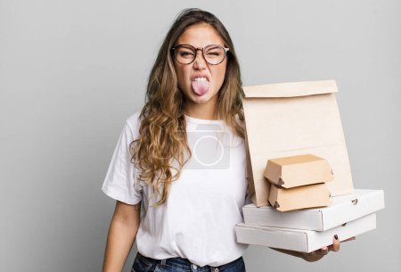 Photo for Hispanic pretty woman feeling disgusted and irritated and tongue out. with fast food packages - Royalty Free Image