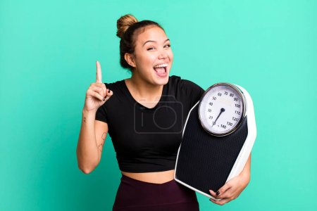 Foto de Hispanic pretty woman feeling like a happy and excited genius after realizing an idea. fitness and diet concept - Imagen libre de derechos
