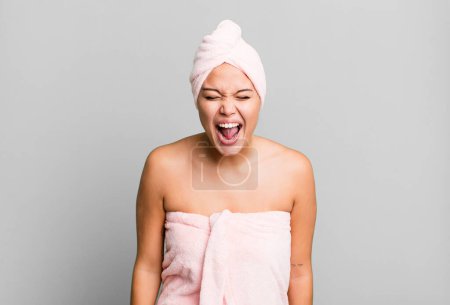 Photo for Hispanic pretty woman shouting aggressively, looking very angry wearing bathrobe. beauty concept - Royalty Free Image