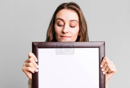 Téléchargez les photos : Jeune jolie femme tenant un cadre vide copie espace - en image libre de droit