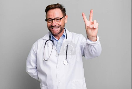 Foto de Hombre de mediana edad sonriendo y mirando feliz, haciendo gestos de victoria o paz. concepto médico - Imagen libre de derechos