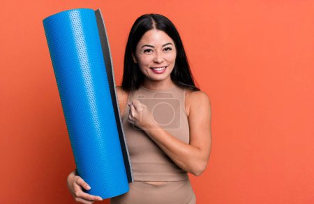 Foto de Hispanic pretty woman feeling happy and facing a challenge or celebrating yoga concept - Imagen libre de derechos