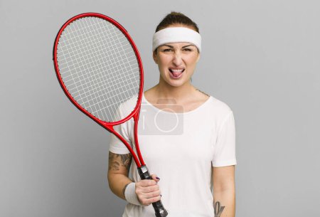 Téléchargez les photos : Jeune jolie femme se sentant dégoûtée et irritée et la langue. concept de tennis - en image libre de droit