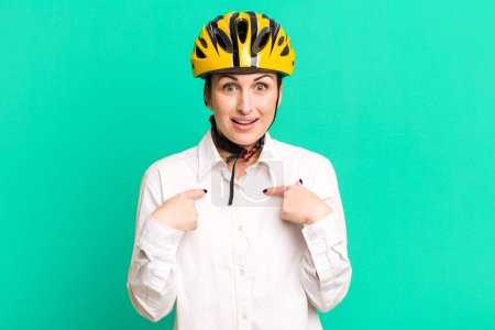 Photo for Young pretty woman feeling happy and pointing to self with an excited. business and bike concept - Royalty Free Image