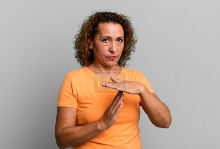 Photo for Middle age hispanic woman looking serious, stern, angry and displeased, making time out sign - Royalty Free Image