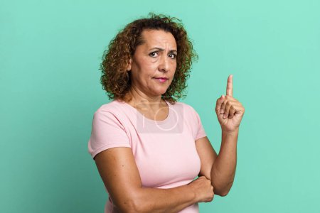 Photo for Middle age hispanic woman feeling like a genius holding finger proudly up in the air after realizing a great idea, saying eureka - Royalty Free Image