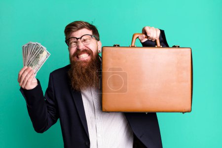 Foto de Joven adulto pelo rojo barbudo fresco hombre de negocios con una maleta de cuero - Imagen libre de derechos