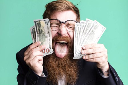 Foto de Joven adulto pelo rojo barbudo fresco hombre de negocios con dollarbanknotes - Imagen libre de derechos