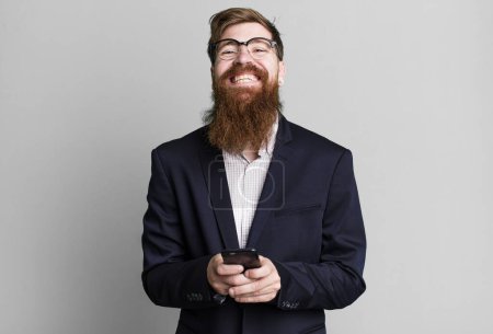 Photo for Young adult red hair bearded cool businessman using his smartphone - Royalty Free Image