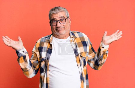 Photo for Middle age senior man feeling puzzled and confused, doubting, weighting or choosing different options with funny expression - Royalty Free Image