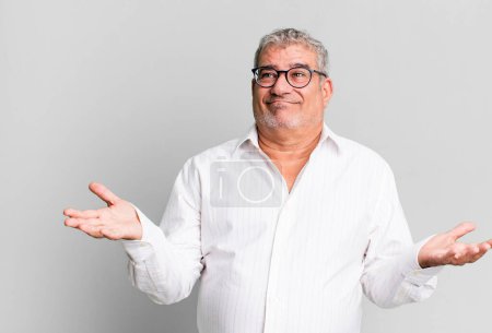Photo for Middle age senior man feeling puzzled and confused, unsure about the correct answer or decision, trying to make a choice - Royalty Free Image
