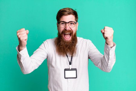 Foto de Barba larga hombre sintiéndose sorprendido, riendo y celebrando el éxito. concepto de acreditación vip badge - Imagen libre de derechos