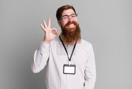Téléchargez les photos : Barbe longue homme se sentant heureux, montrant l'approbation avec un geste correct. vip badge concept d'accréditation - en image libre de droit