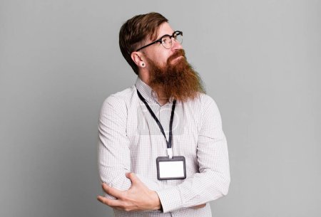 Téléchargez les photos : Barbe longue homme haussant les épaules, se sentant confus et incertain. vip badge concept d'accréditation - en image libre de droit
