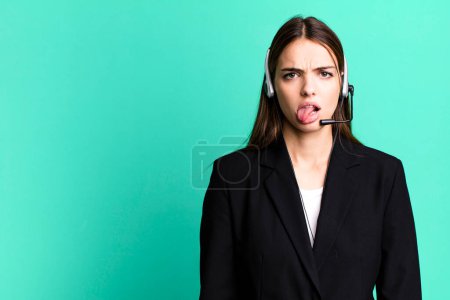 Téléchargez les photos : Young pretty woman feeling disgusted and irritated and tongue out. telemarketing agent concept - en image libre de droit
