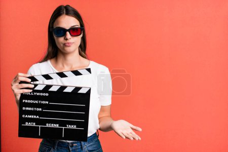 Photo for Young pretty woman feeling puzzled and confused and doubting. cinema film or movie concept - Royalty Free Image