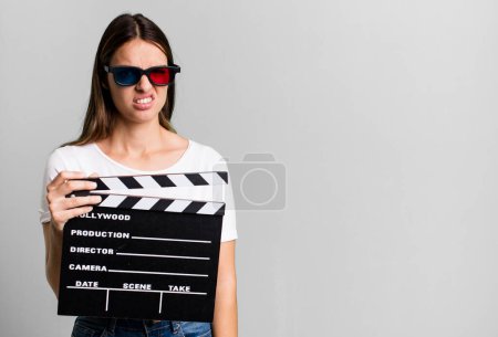 Photo for Young pretty woman feeling puzzled and confused. cinema film or movie concept - Royalty Free Image