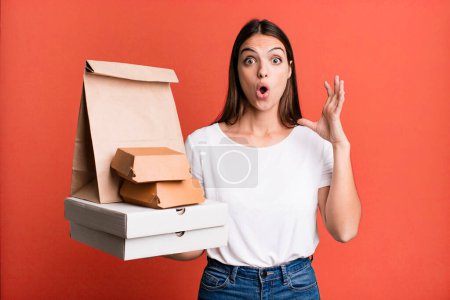 Foto de Young pretty woman screaming with hands up in the air. delivery and take away concept - Imagen libre de derechos