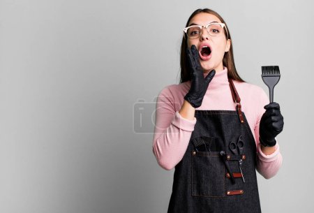 Téléchargez les photos : Young pretty woman feeling happy,giving a big shout out with hands next to mouth. hair dryer concept - en image libre de droit