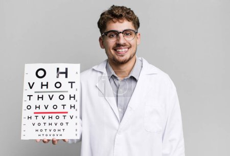 Photo for Young adult caucasian man smiling happily with a hand on hip and confident. optical vision test concept - Royalty Free Image