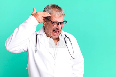 Photo for Middle age senior man looking unhappy and stressed, suicide gesture making gun sign. physician or doctor concept - Royalty Free Image