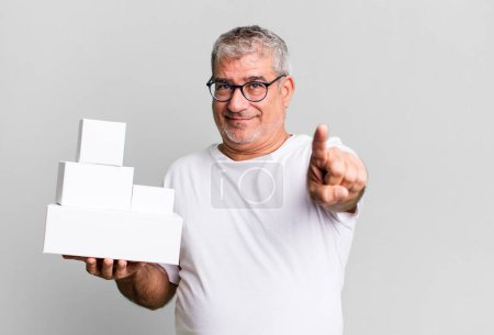 Téléchargez les photos : Senior d'âge moyen souriant fièrement et en toute confiance faisant numéro un. différents paquets boîtes vides - en image libre de droit
