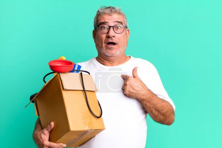 Photo for Middle age senior man looking shocked and surprised with mouth wide open, pointing to self. housekeeper repairman with a toolbox concept - Royalty Free Image