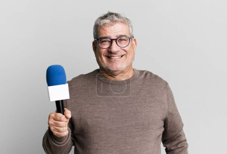 Photo for Middle age senior man smiling happily with a hand on hip and confident. journalist or tv presenter with a micro - Royalty Free Image