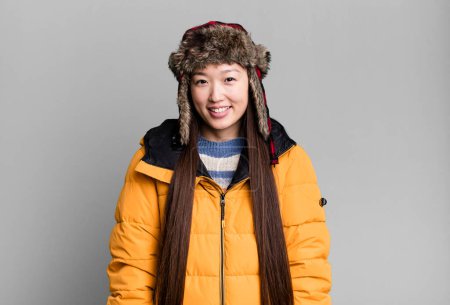 Photo for Young adult pretty asian woman wearing anorak and winter hat - Royalty Free Image