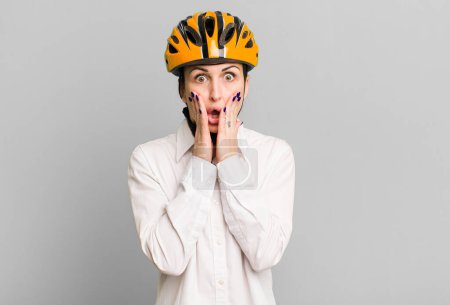 Téléchargez les photos : Young pretty woman feeling shocked and scared. business and bike concept - en image libre de droit
