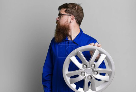 Foto de Barba larga hombre en vista de perfil pensando, imaginando o soñando despierto. concepto mecánico de coche - Imagen libre de derechos