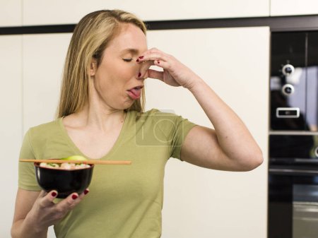 Foto de Young adult pretty blonde woman eating a ramen noodles bowl - Imagen libre de derechos