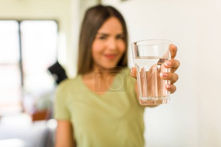 Foto de Pretty latin woman with a water glass at home - Imagen libre de derechos