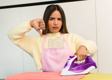 Foto de Pretty latin woman housekeeper. iron clothes concept - Imagen libre de derechos