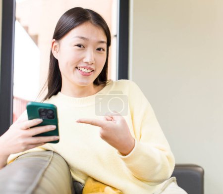 Téléchargez les photos : Asian pretty woman using a smartphone and shopping at home - en image libre de droit