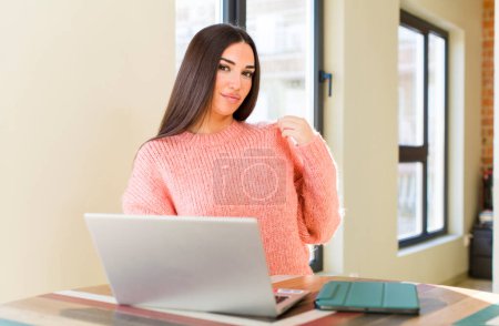Foto de Bonita mujer joven con un ordenador portátil en un escritorio en casa - Imagen libre de derechos