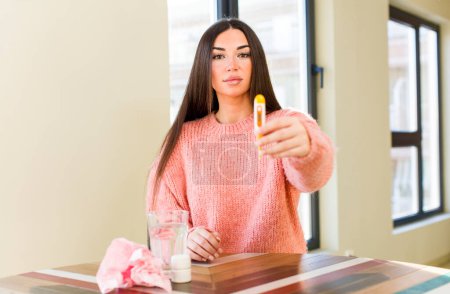 Téléchargez les photos : Jeune jolie femme avec un verre d'eau et des pilules. concept de grippe - en image libre de droit