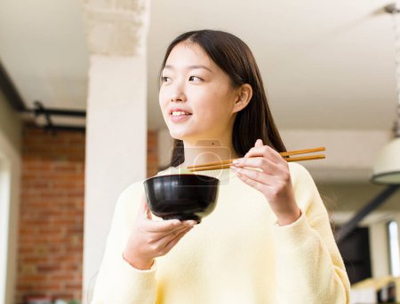 Foto de Asian pretty woman eating a ramen noodles bowl - Imagen libre de derechos