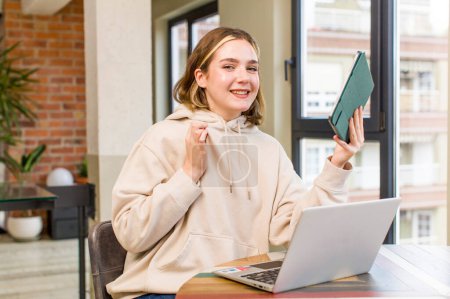 Foto de Mujer joven y bonita con un ordenador portátil que trabaja en casa. casa de diseño de interiores - Imagen libre de derechos