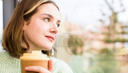 Photo for Pretty young woman with a hot coffee at home. house interior design - Royalty Free Image
