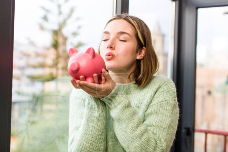 Photo for Pretty young woman with a piggy bank. savings concept. house interior design - Royalty Free Image
