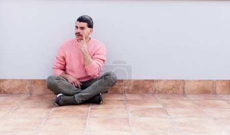 Photo for Young handsome man sitting on the floors with a copyspace - Royalty Free Image