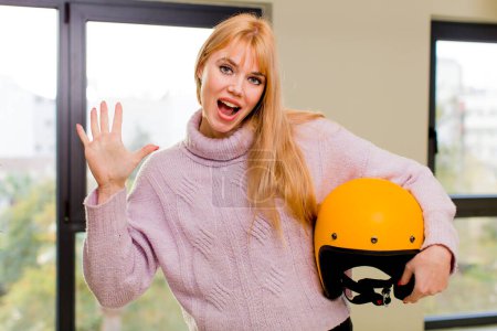 Foto de Joven bonita mujer con un casco de moto en el interior de casa - Imagen libre de derechos