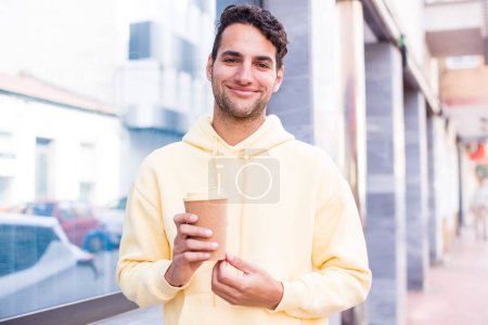 Photo for Hispanic handsome man with a hot take away coffee drink. outdoors concept - Royalty Free Image