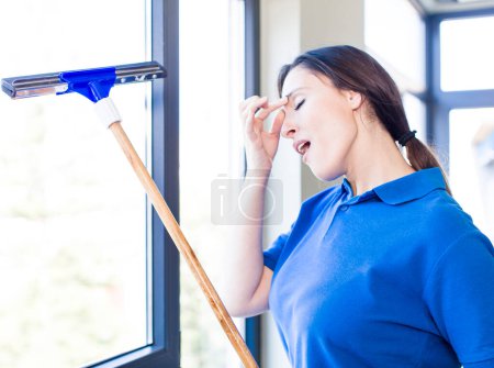 Foto de Young adult windows washer concept. cleaning house interior - Imagen libre de derechos