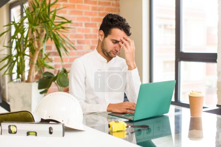 Photo for Young hispanic man feeling stressed, unhappy and frustrated, touching forehead and suffering migraine of severe headache. architect concept - Royalty Free Image