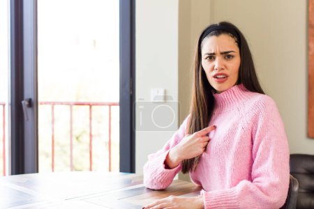 Foto de Pretty caucasian woman looking shocked and surprised with mouth wide open, pointing to self - Imagen libre de derechos