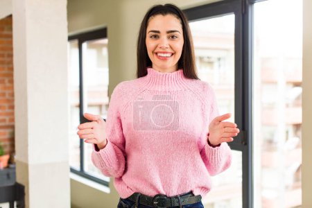 Photo for Pretty caucasian woman holding an object with both hands on copy space, showing, offering or advertising an object - Royalty Free Image