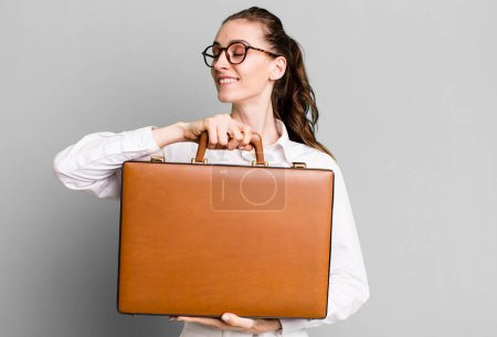 Téléchargez les photos : Jeune jolie femme avec une valise en cuir. concept d'entreprise - en image libre de droit